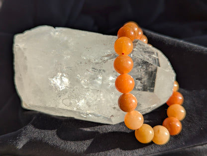 Macro close-up view of polished 10mm Orange Aventurine spheres, highlighting the vitreous surface luster and subtle internal mineral inclusions characteristic of high-grade quartzite.