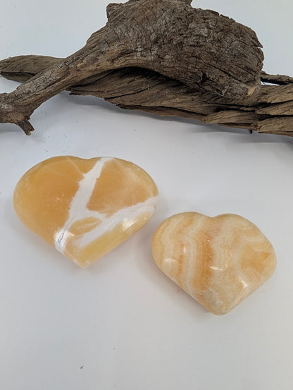 Comparison of Small and Medium Orange Calcite hearts showing vibrant citrus color.