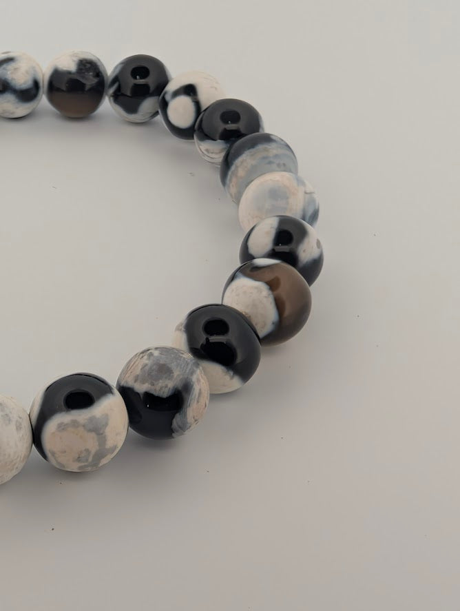 Detail of Orca Agate bracelet highlighting glossy polish and black-white patterns