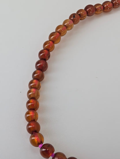 Close-up of 3mm peach garnet beads showing translucent lustre