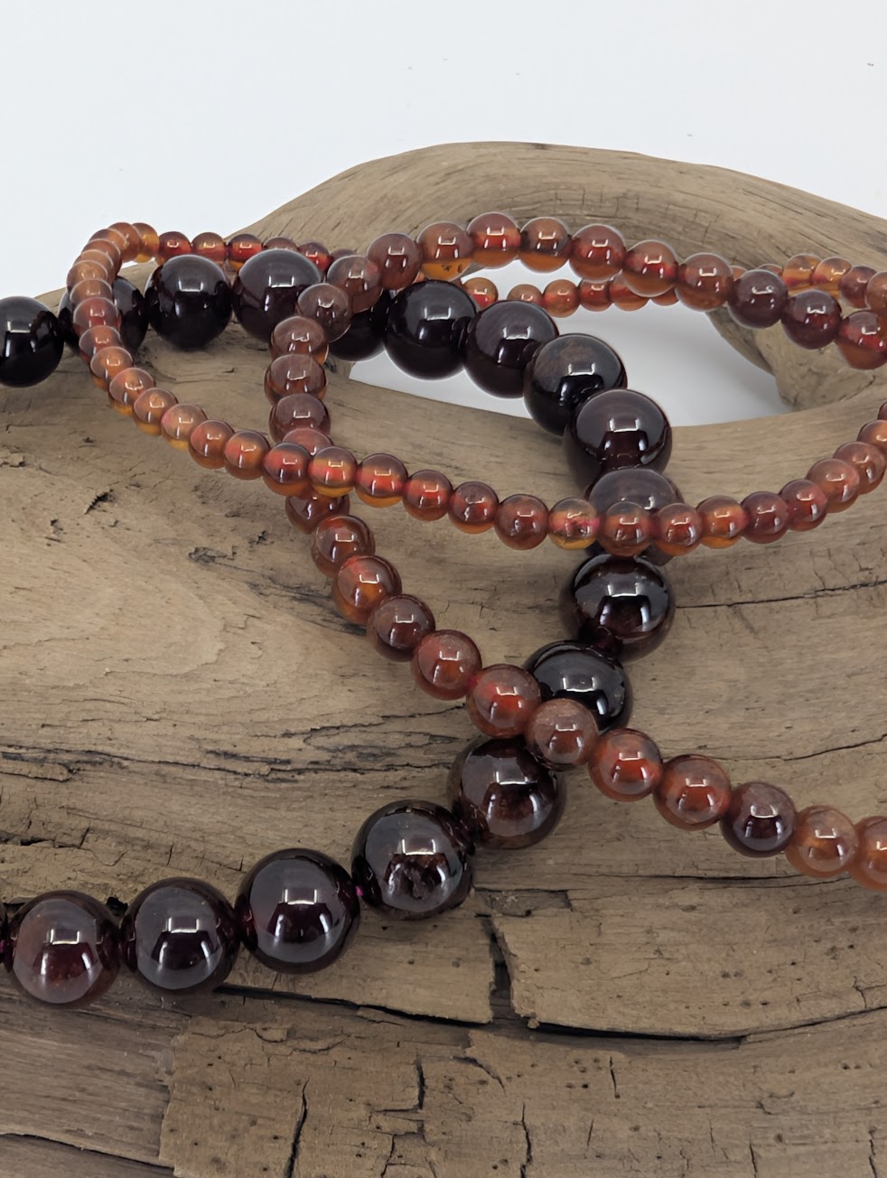 Close-up of peach garnet bracelet trio showing warm amber translucency