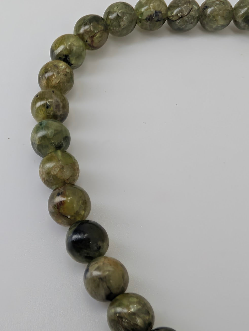Close-up of 5 mm peridot beads showing fresh apple-green color