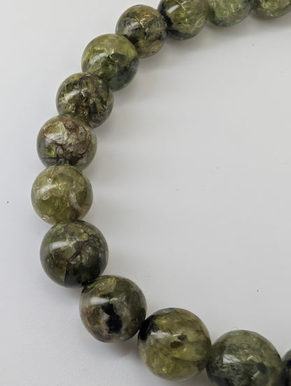 Close-up of 7 mm peridot beads showing high polish and natural inclusions