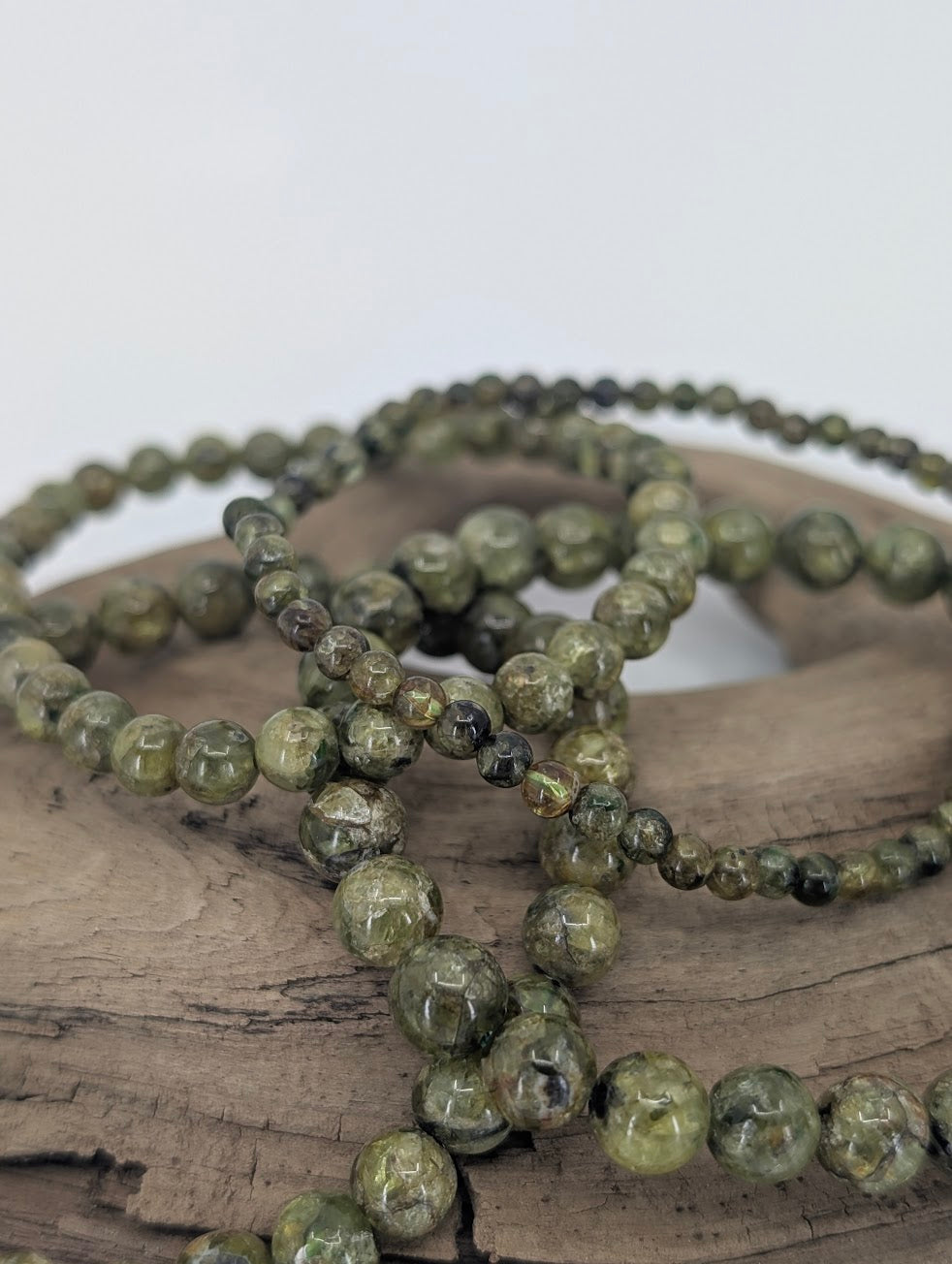 Close-up of multiple peridot bracelets showing natural green and texture