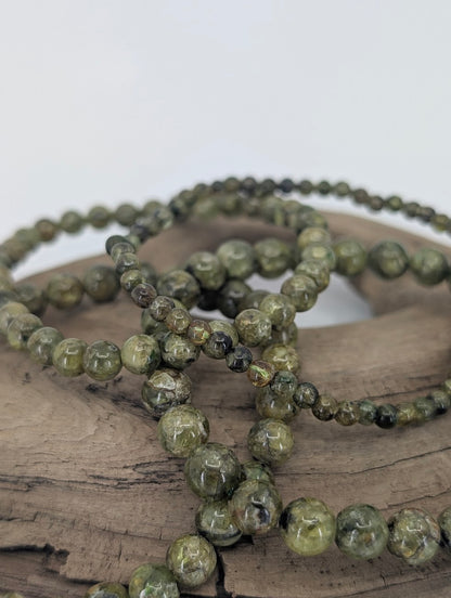Close-up of multiple peridot bracelets showing natural green and texture