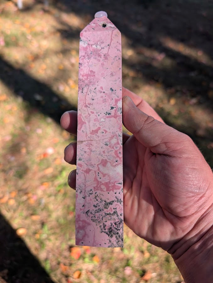 Back view of rhodonite tower #5 showing tall polished profile with dark manganese streaks