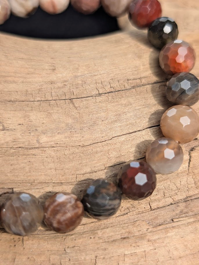 Macro close-up of 8mm faceted Petrified Wood beads highlighting geometric surface cuts and natural fossilized grain patterns.
