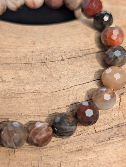 Macro close-up of 8mm faceted Petrified Wood beads highlighting geometric surface cuts and natural fossilized grain patterns.