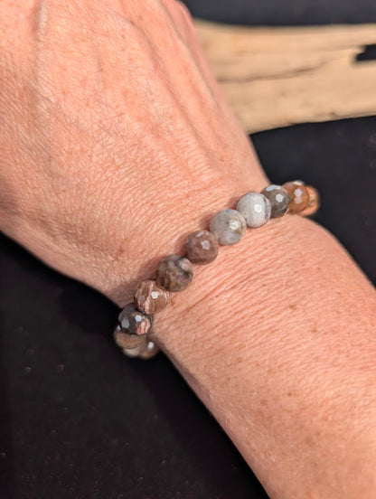 8mm faceted Petrified Wood beaded stretch bracelet worn on a wrist for size scale.