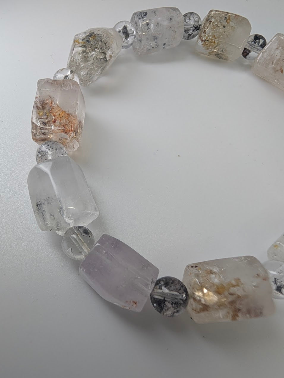 Detailed bead view showing petroleum inclusions inside quartz.