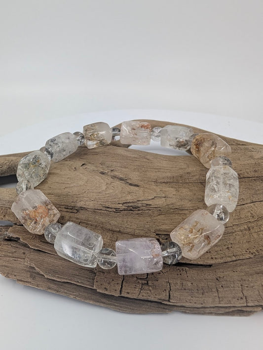 Petroleum quartz bracelet with UV-reactive hydrocarbon inclusions – close-up view.