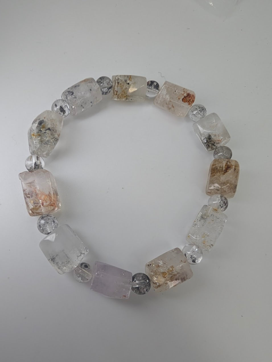 Full view of petroleum quartz bracelet with hydrocarbon inclusions.