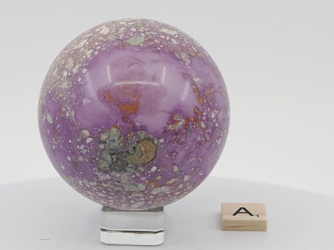 Close-up of a 74mm orchid-purple Phosphosiderite sphere with natural crystalline vugs and inclusions.