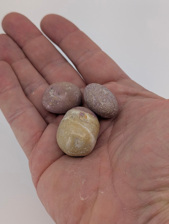 Phosphosiderite tumbled stones in hand for size reference