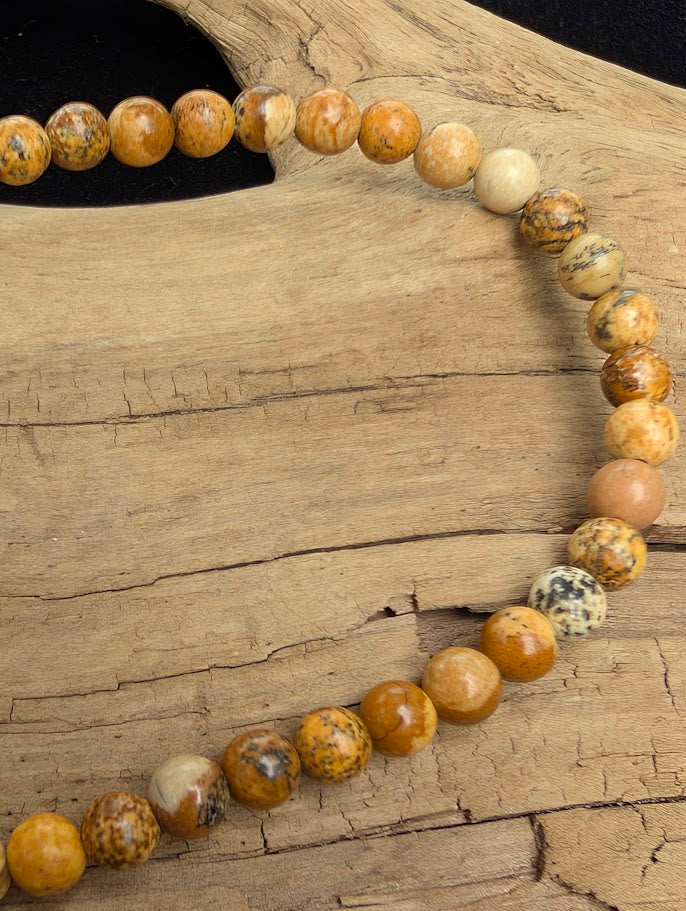 Macro close-up of 4mm smooth Picture Jasper beads highlighting the high-gloss polish and natural landscape-like banding.