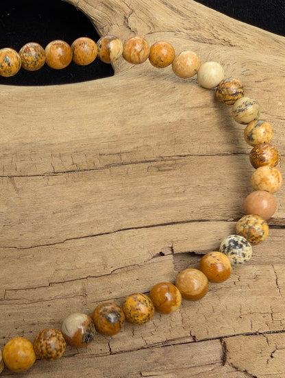 Macro close-up of 4mm smooth Picture Jasper beads highlighting the high-gloss polish and natural landscape-like banding.