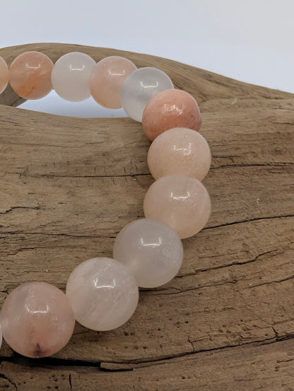 Closeup of Pink Aventurine 8mm beads showing soft peach tones and natural inclusions