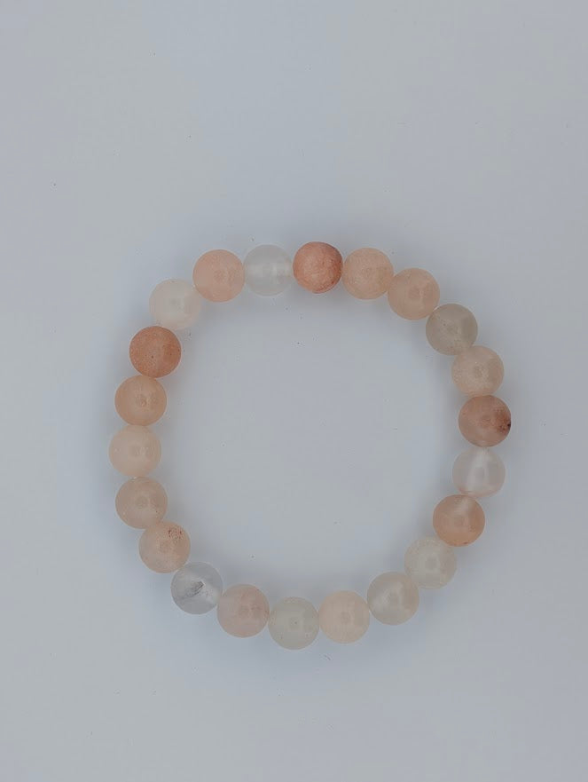 Overhead view of Pink Aventurine 8mm round bead bracelet in a circle on light background