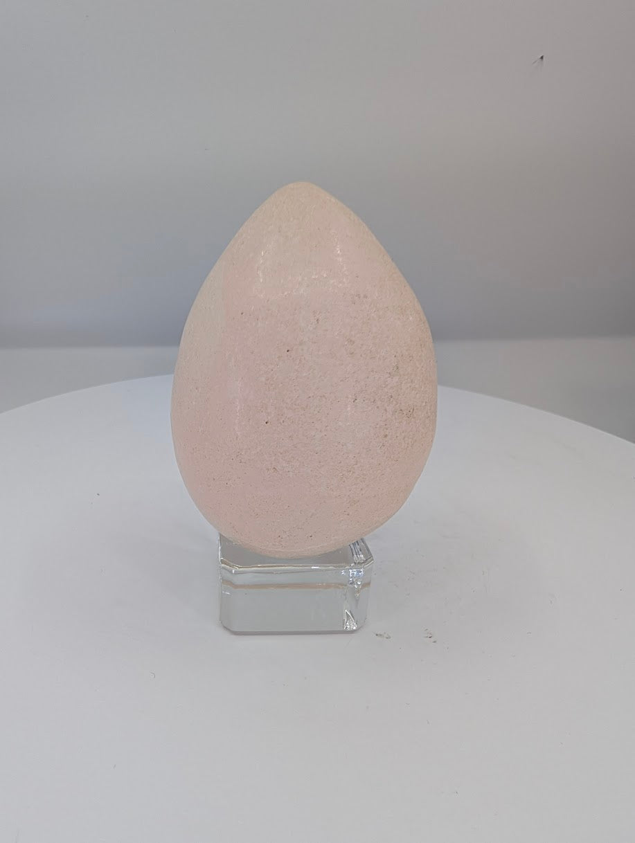 Polished pink calcite egg approximately 2.75 inches tall with soft blush tones