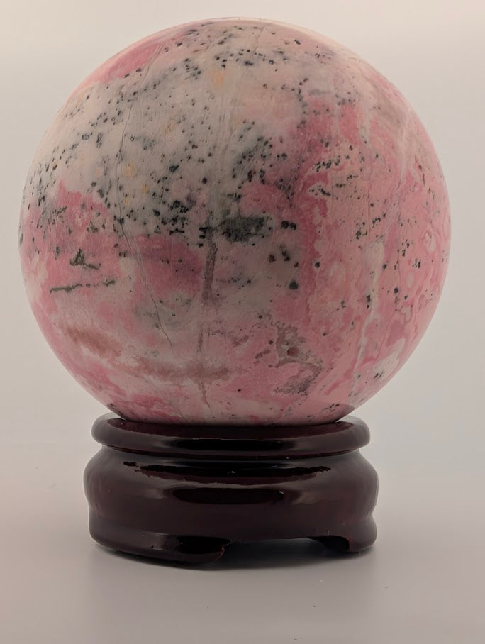 Side view of rhodonite sphere with natural pattern variations