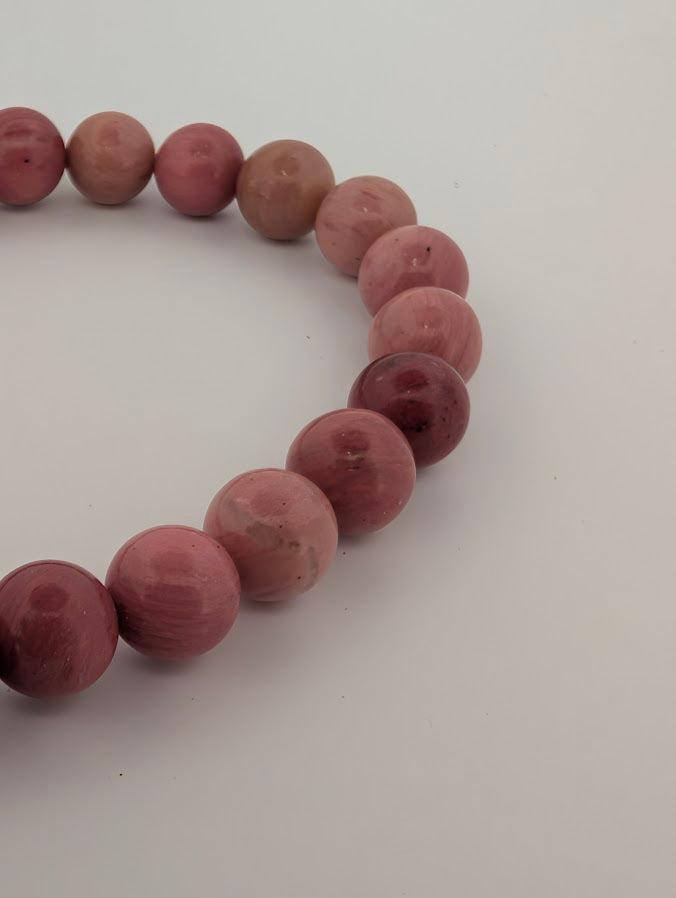 Detail of fossil wood bead texture and rose tones
