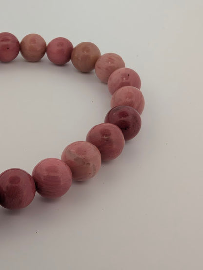 Detail of fossil wood bead texture and rose tones