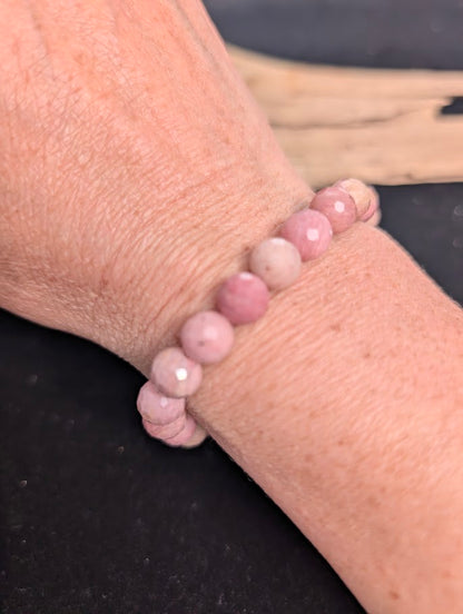 8mm faceted Pink Petrified Wood beaded stretch bracelet worn on a wrist for size scale.