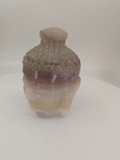 Pink Pistachio Calcite Buddha head carving, 9 cm, angled side view