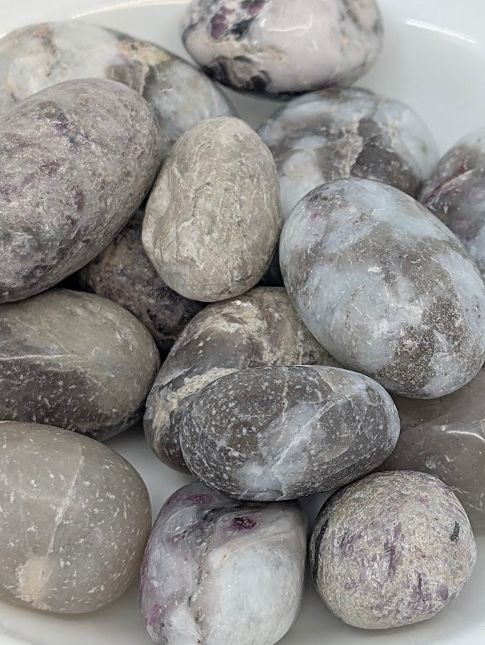 Close-up of Pink Tourmaline in Quartz tumbled stones showing pink veining