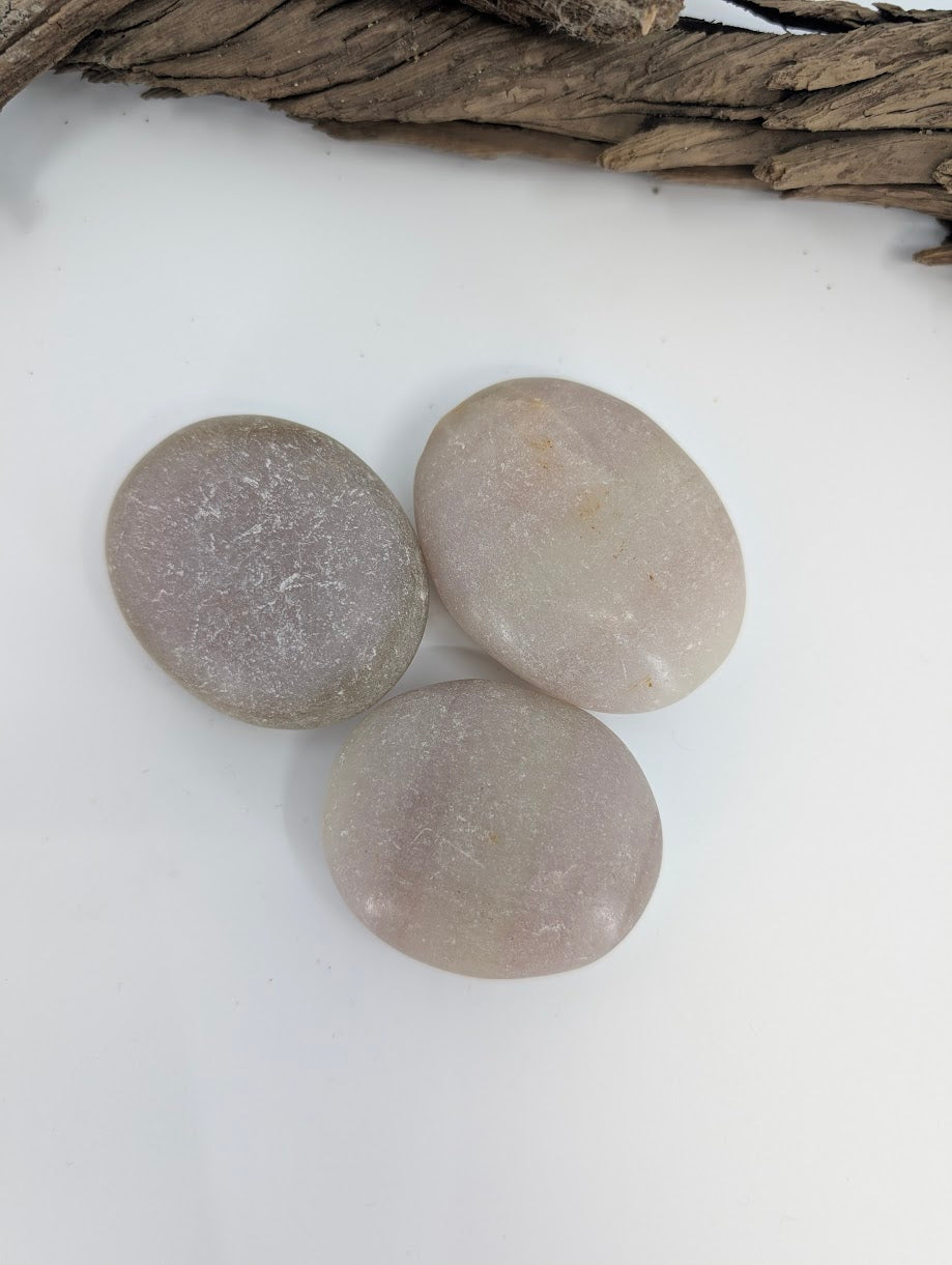 Group of Pistachio Calcite palm stones showing natural color variation