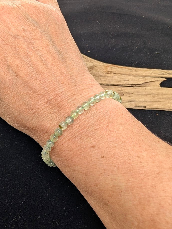 4mm polished Prehnite beaded stretch bracelet worn on a wrist for delicate size scale.