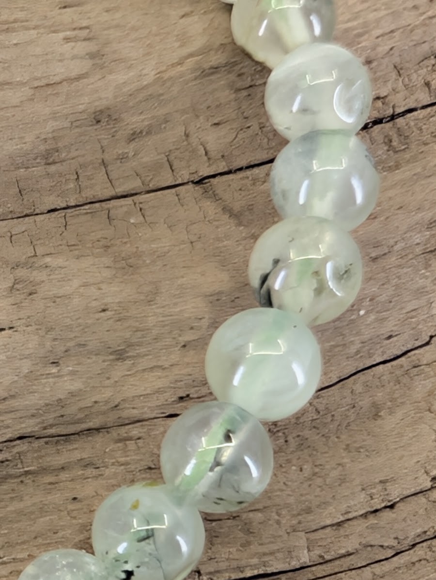 Macro view of South African Prehnite beads showing the sub-vitreous luster and authentic mineral inclusions.
