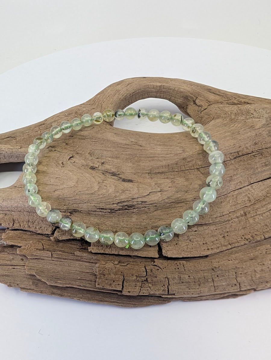 4.5mm Prehnite bracelet with Epidote inclusions from South Africa shown on natural wood.