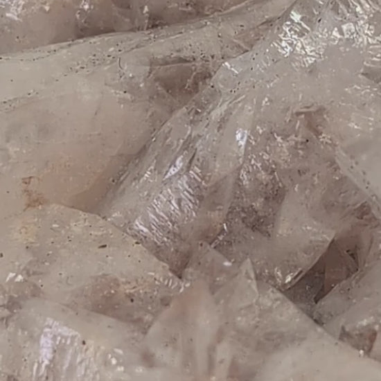 Detailed video showcasing an all-natural Swallowtail Pink Calcite cluster from Hunan, China. The footage highlights the translucent peach-pink calcite blades, classic swallowtail twin formations, and untouched crystal growth across the matrix.