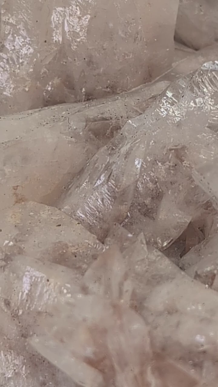 Detailed video showcasing an all-natural Swallowtail Pink Calcite cluster from Hunan, China. The footage highlights the translucent peach-pink calcite blades, classic swallowtail twin formations, and untouched crystal growth across the matrix.