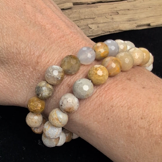 Video showcasing the highly reflective faceted texture and natural earthy, floral fossil patterns of an 8mm Coral Jade beaded stretch bracelet worn on a wrist.