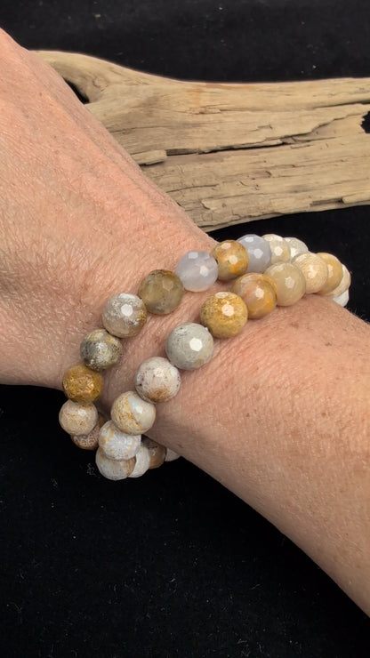 Video showcasing the highly reflective faceted texture and natural earthy, floral fossil patterns of an 8mm Coral Jade beaded stretch bracelet worn on a wrist.