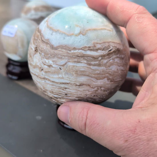 Video overview showcasing the complete lot of five exact-piece Blue Aragonite and Caribbean Calcite spheres from Balochistan, Pakistan, highlighting their varying sizes, polished banding, and natural vugs.