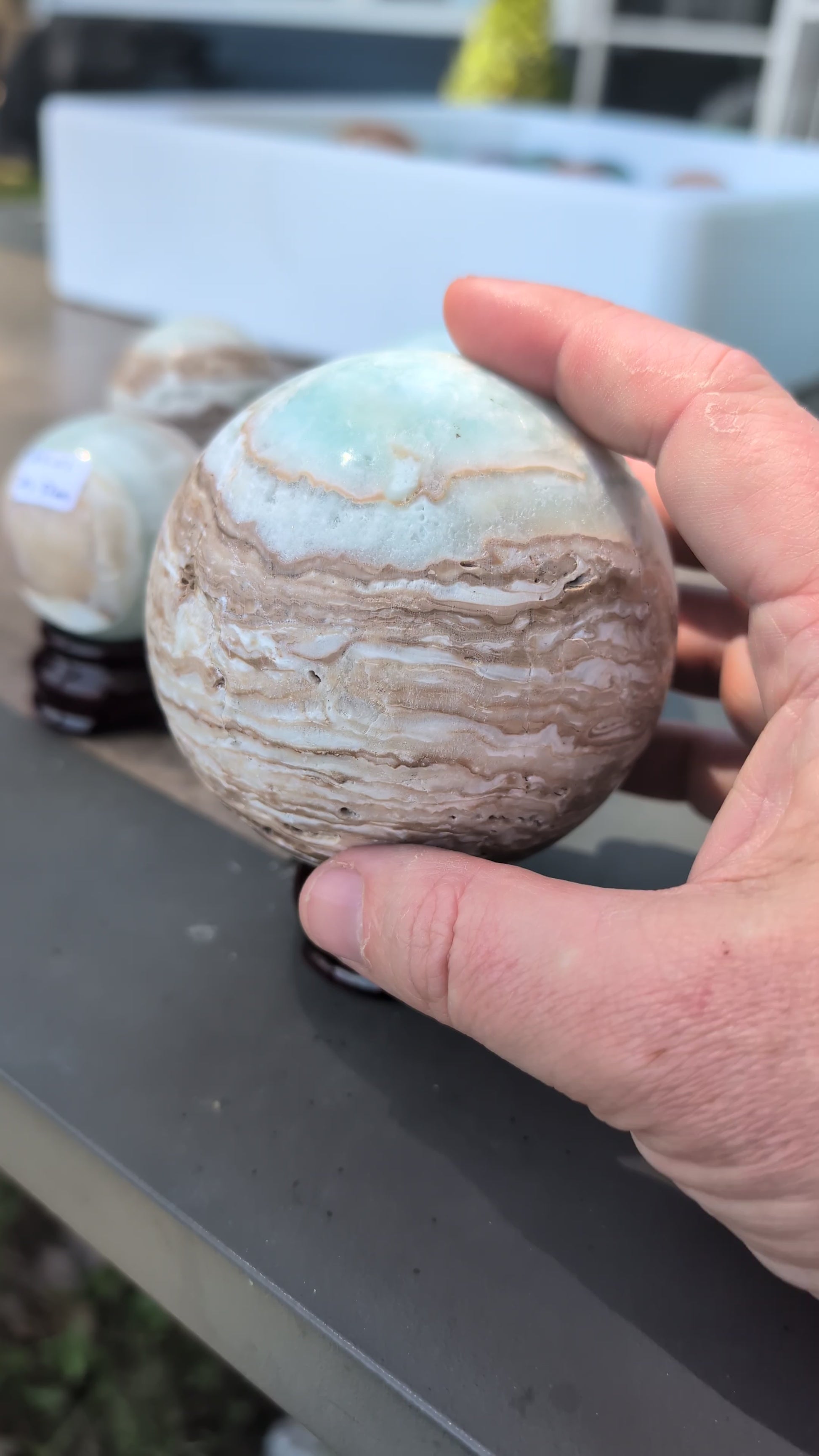 Video overview showcasing the complete lot of five exact-piece Blue Aragonite and Caribbean Calcite spheres from Balochistan, Pakistan, highlighting their varying sizes, polished banding, and natural vugs.