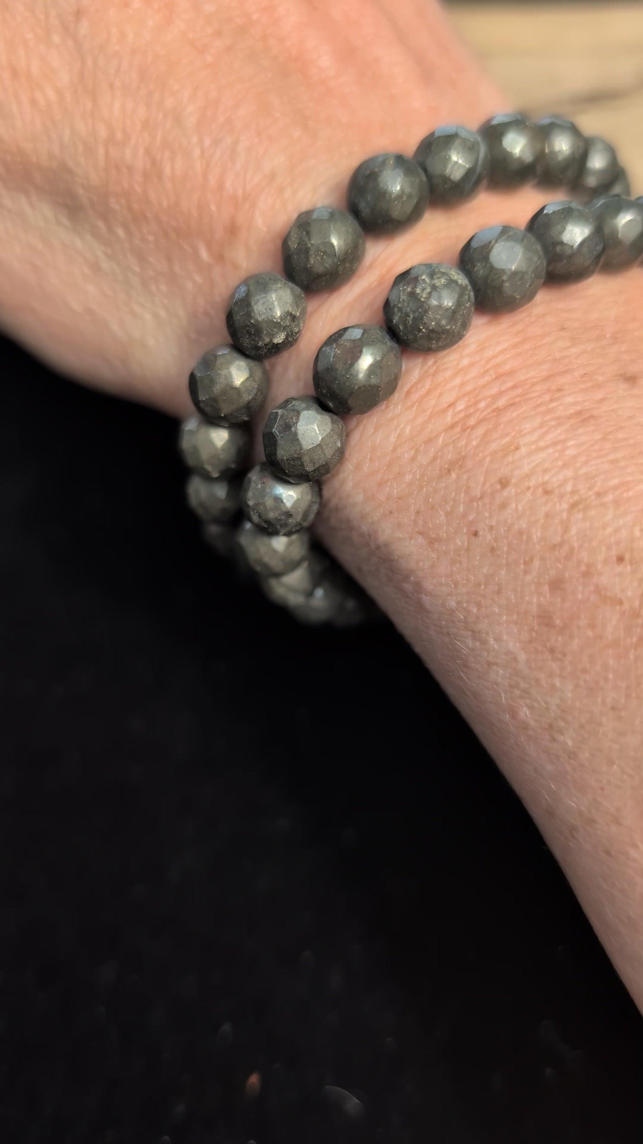 Video showcasing the highly reflective faceted texture and brilliant metallic lustre of an 8mm Pyrite beaded stretch bracelet worn on a wrist.
