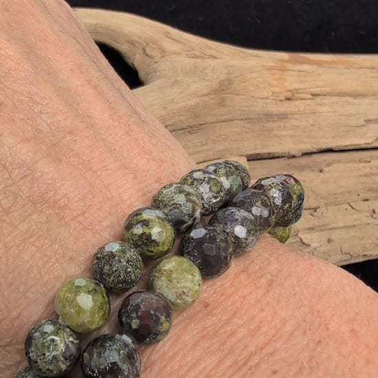 Video showcasing the highly reflective faceted texture and natural green and red mottled patterns of an 8mm Dragon Blood Stone beaded stretch bracelet worn on a wrist.