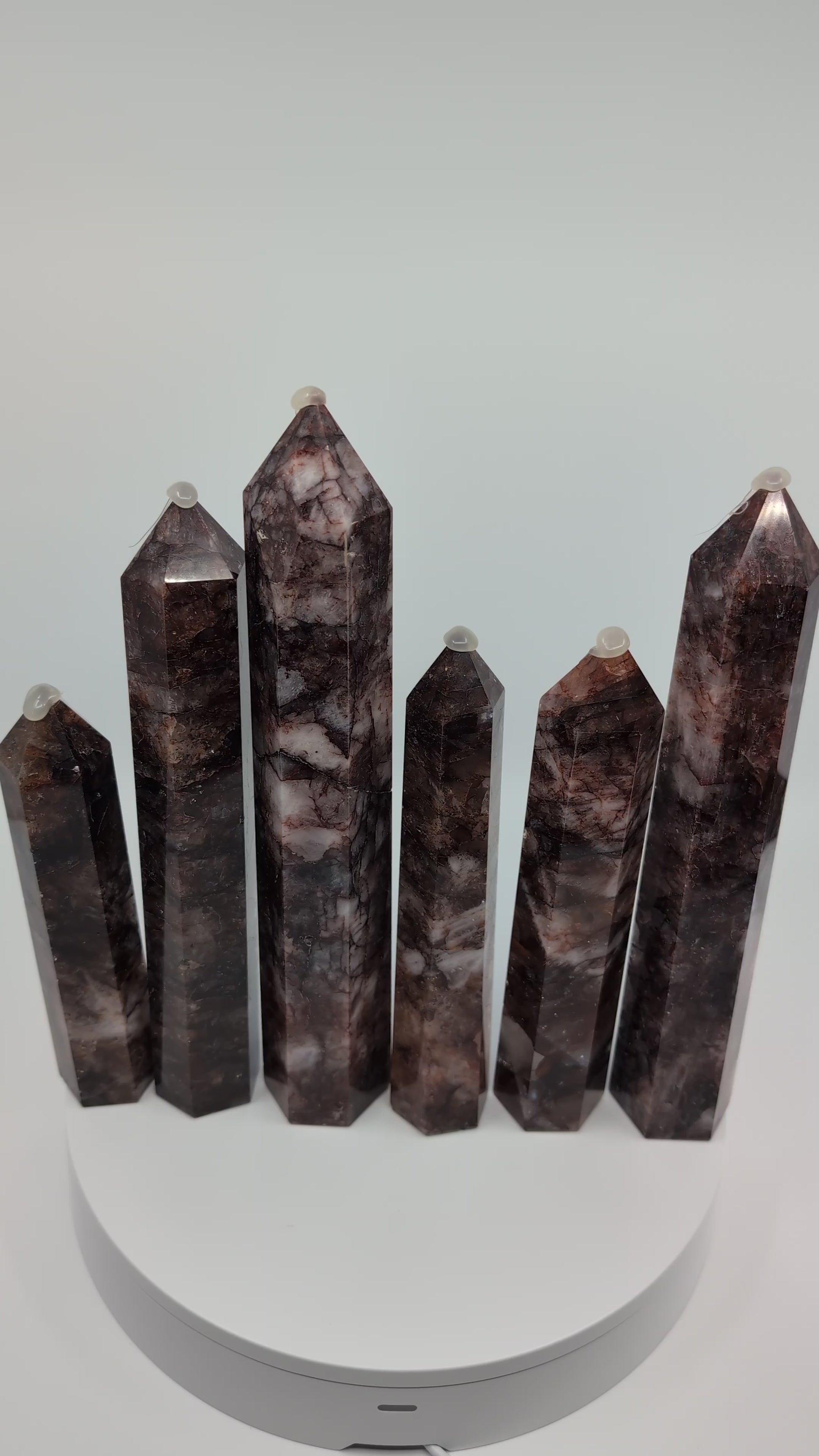 Video showcasing multiple Brazilian Fire Quartz towers in various sizes. Polished hematoid quartz points with fiery red hematite inclusions rotating under natural light