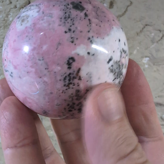 of Pink Peruvian Rhodonite sphere showing pink and white gradient