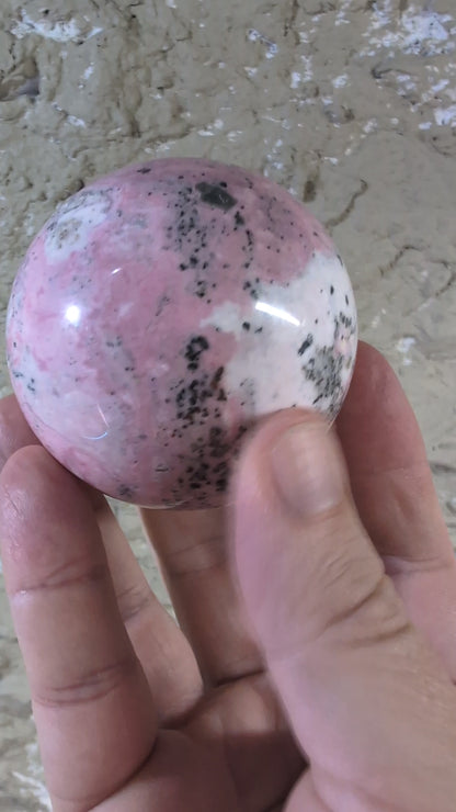 of Pink Peruvian Rhodonite sphere showing pink and white gradient