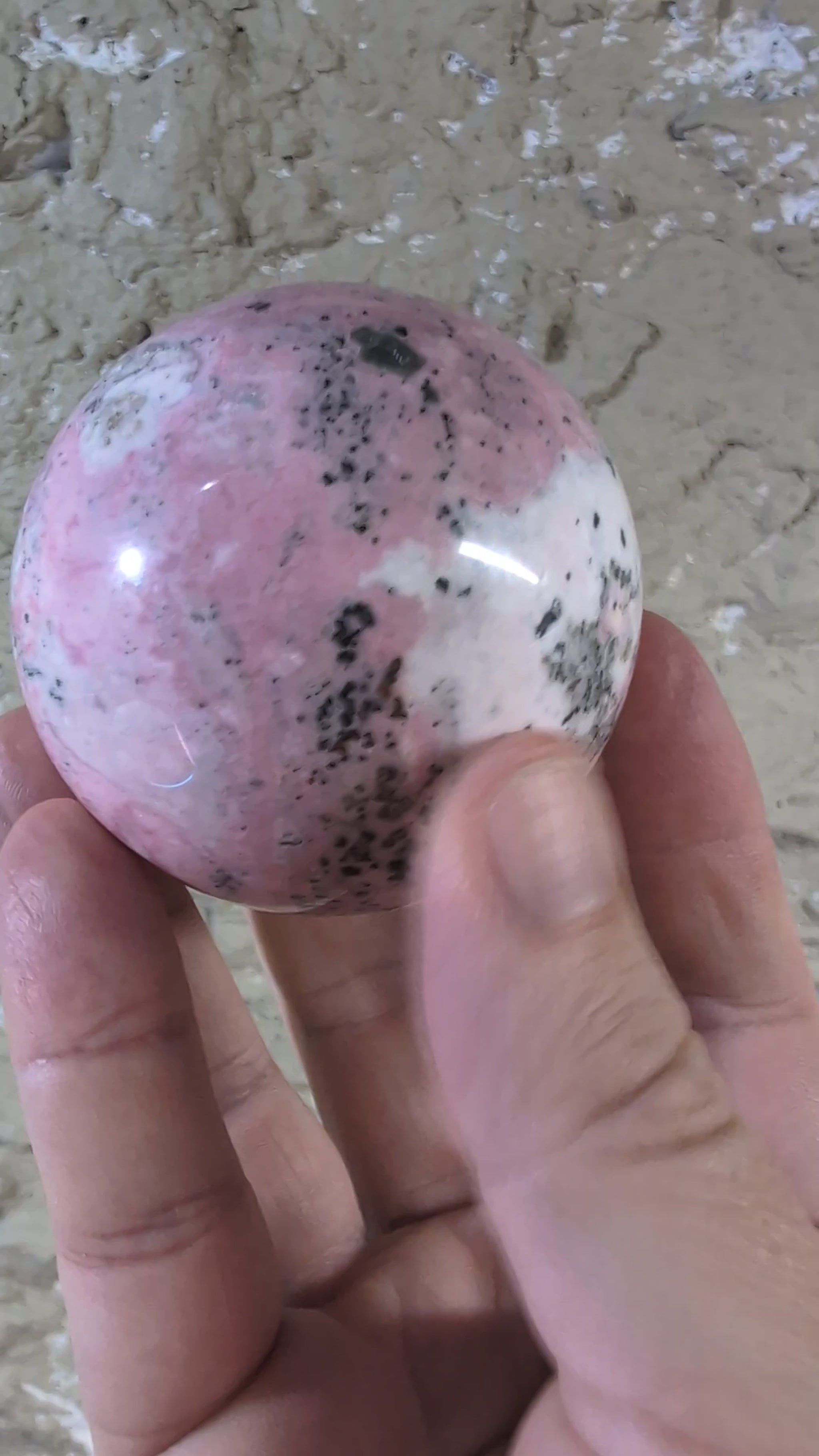 of Pink Peruvian Rhodonite sphere showing pink and white gradient