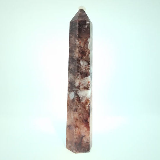 Video showcasing multiple Brazilian Fire Quartz towers in various sizes. Polished hematoid quartz points with fiery red hematite inclusions rotating under natural light.