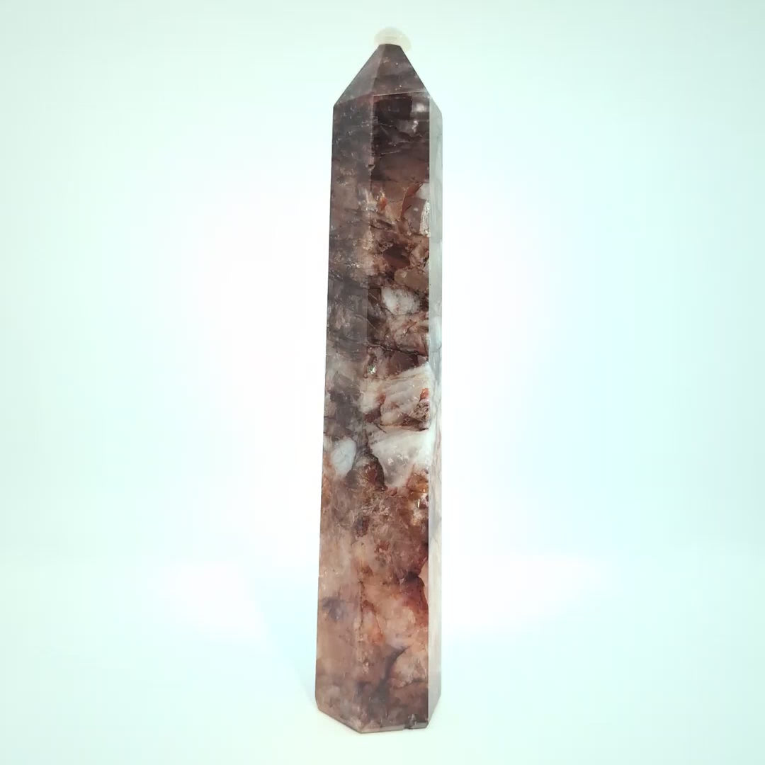 Video showcasing multiple Brazilian Fire Quartz towers in various sizes. Polished hematoid quartz points with fiery red hematite inclusions rotating under natural light.