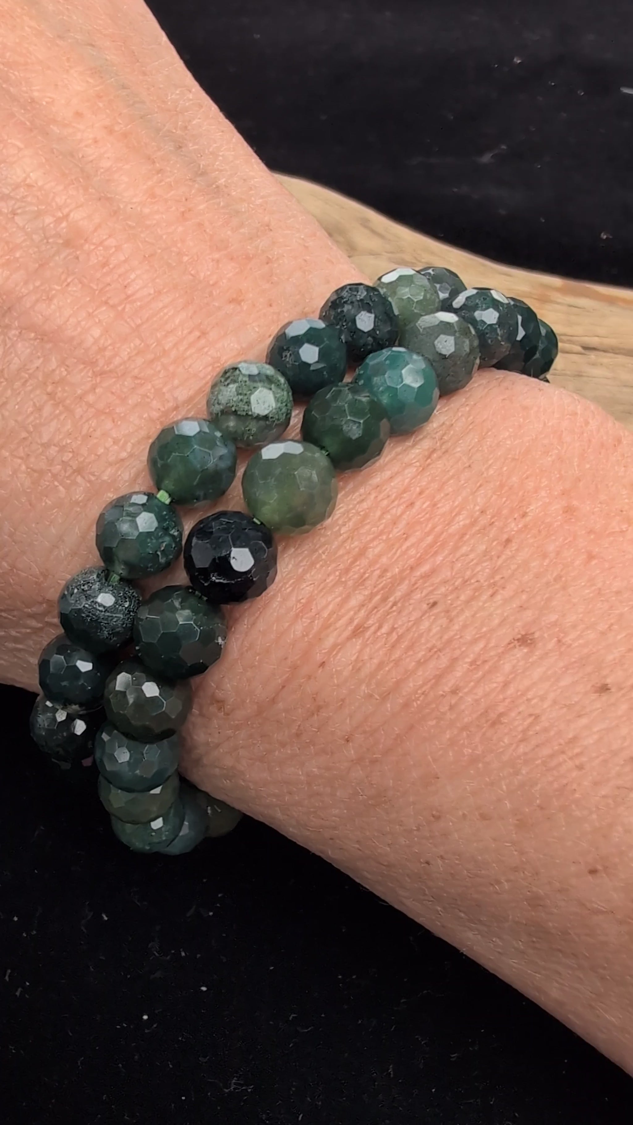 Video demonstrating the 8mm faceted Moss Agate beaded stretch bracelet in motion, highlighting the light-catching geometric cuts and the deep green dendritic moss formations suspended within the stones.