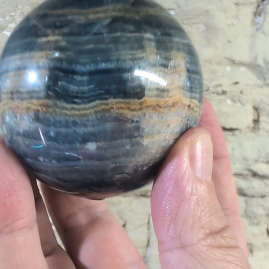 Video of 67mm blue onyx sphere showing golden seam and banded contrast