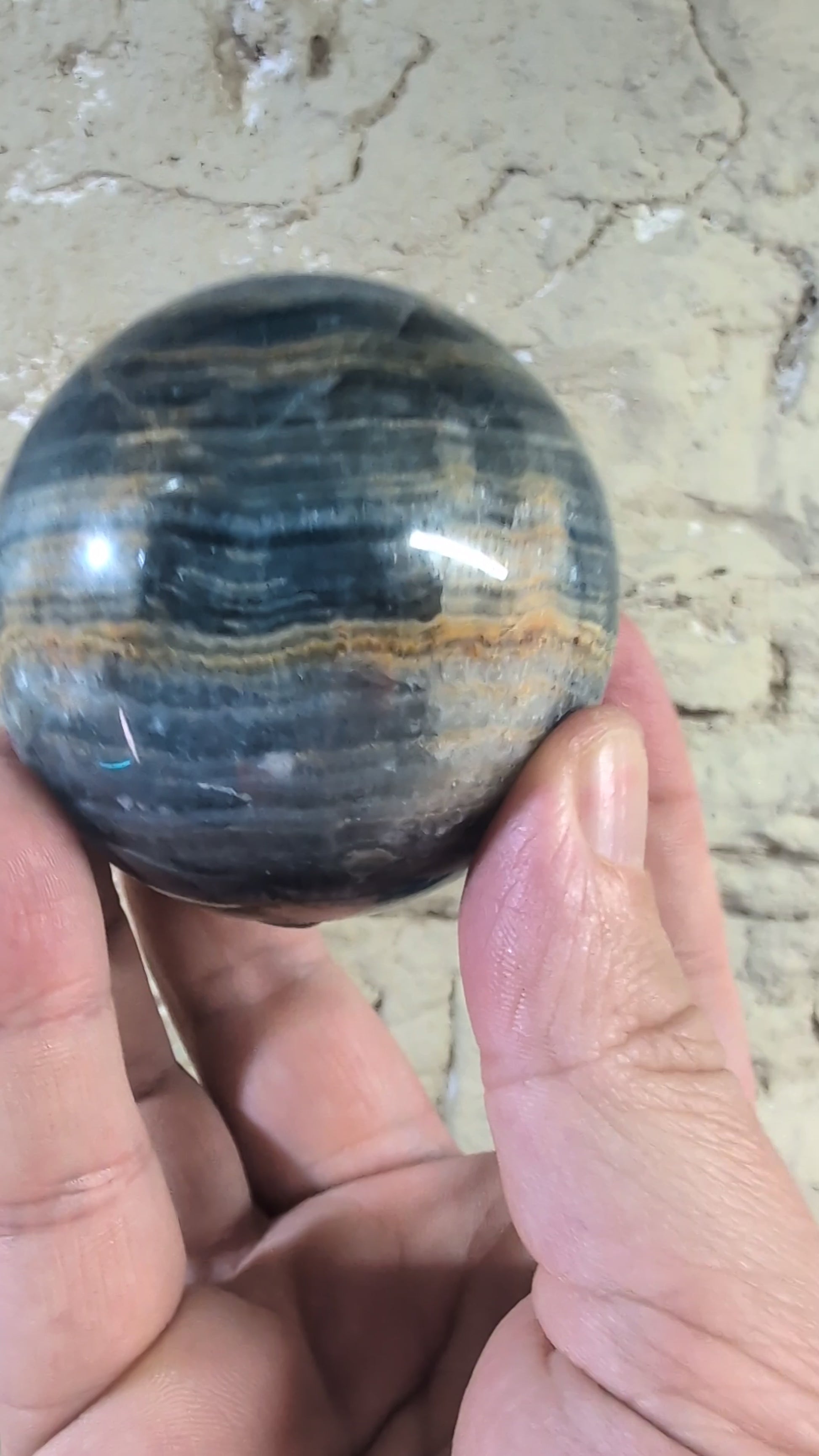 Video of 67mm blue onyx sphere showing golden seam and banded contrast
